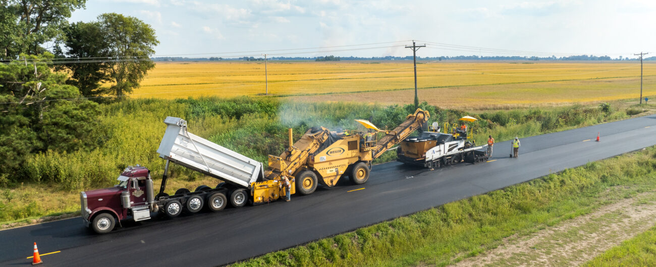 Dump trucks and equipment working on a road construction project.